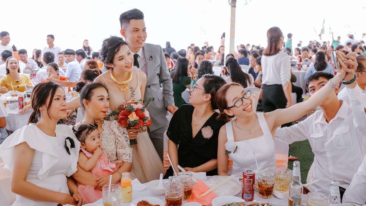 Guests laughing and raising their glasses around a long table